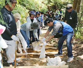 熊野古道に土を運び入れる道普請の参加者（１４日、和歌山県田辺市本宮町で）