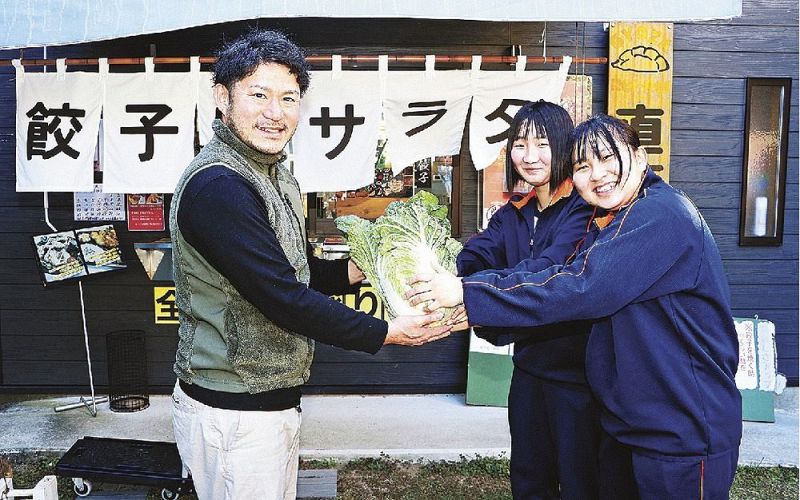 岡林大介さん（左）に自分たちの育てたハクサイを届ける熊野高校の生徒＝和歌山県上富田町市ノ瀬で