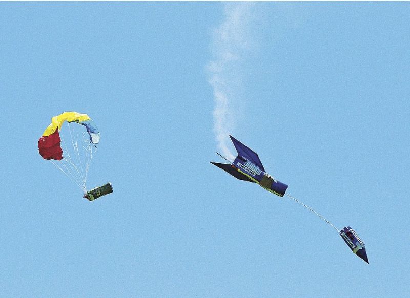 上空でモデルロケットから放出され、パラシュートで降下する缶サット（左）＝いずれも和歌山県串本町潮岬で