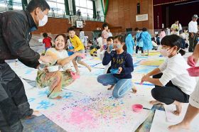 新宅百絵さん（左から２人目）と一緒に絵の具を使って遊ぶ児童ら＝和歌山県みなべ町谷口で
