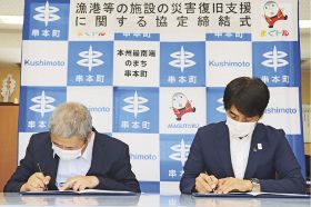 協定書に署名する田嶋勝正町長（右）と吉塚靖浩理事長＝２日、和歌山県串本町串本で