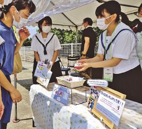 来場者（左）に梅干しを紹介するシーカーのメンバー＝２日、和歌山県田辺市上の山１丁目で