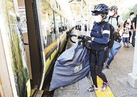自転車を持って特急列車「くろしおサイクル」に乗り込む利用者（１日、和歌山県のＪＲ白浜駅で）