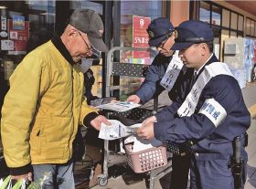 買い物客（左）に啓発品を手渡す白浜署員＝１０日、和歌山県白浜町栄で