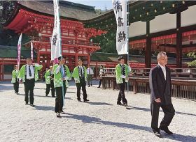 梅干しを奉納するため拝殿に向かう紀州梅の会梅干部会長の濱田洋さん（右）ら会の関係者ら＝１０日、京都市の下鴨神社で
