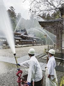 本殿へ向けて放水する参加者（２３日、和歌山県田辺市本宮町の熊野本宮大社で）