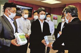 真砂充敏市長（右）にマスクや消毒液を手渡す「田辺異業種交流会」の会員ら＝２１日、和歌山県田辺市の市長室で
