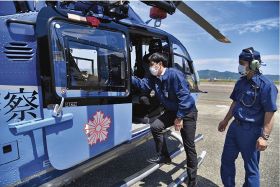 県警航空隊のヘリに乗り込む、県廃棄物指導室の職員（中央）＝２１日、白浜町で
