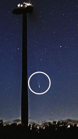 風力発電の風車のそばで輝く西村彗星（円内）＝８日午前４時半、和歌山県印南町樮川で（露光時間２０秒）