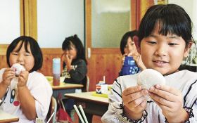 給食で梅干し入りの餅を食べる児童（２５日、和歌山県みなべ町西岩代で）
