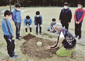 矢倉寛之さん（右手前）から苗木の植え方について説明を受ける児童＝１日、和歌山県古座川町池野山で