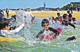 海開きで水を掛け合う児童（１日、和歌山県田辺市扇ケ浜で）