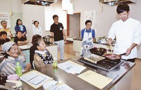 ジビエ料理の仕方を手ほどきする更井亮介さん（右）＝１日、和歌山県田辺市鮎川で
