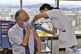 新型コロナウイルスワクチンの接種を受ける日本赤十字社和歌山医療センターの平岡真寛院長（左）＝８日、和歌山市で