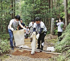 熊野古道の修繕箇所に土を運ぶ、道普請の参加者（和歌山県田辺市本宮町で）