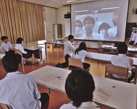 スクリーンに映し出された飯田高校の生徒と会話をする生徒ら（和歌山県串本町串本で）