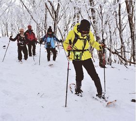 スノーシューを履いて雪の上を歩く参加者
