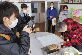 利用者の作業風景をスマートフォンで撮影する神島高校の生徒（左）＝和歌山県田辺市たきない町で