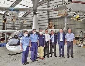 ヘリコプターの前に並ぶ、和歌山県警白浜署の阪口豊署長（左から２人目）と全日本ヘリコプター協議会の橋本浩二理事長（左から３人目）＝１４日、和歌山県白浜町で