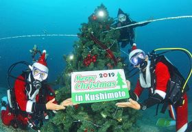 海底に設置したクリスマスツリーと記念撮影する組合員（２７日、和歌山県串本町潮岬沖で）＝串本ダイビング事業組合提供