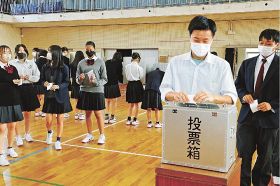 実際の選挙で使用する投票箱や記載台を使って、投票を体験する熊野高校の生徒（和歌山県上富田町朝来で）