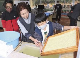 児童に紙すきを教える谷本節代さん（左から２人目）＝古座川町三尾川で
