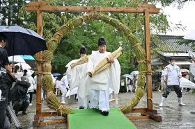 半年でたまった汚（けが）れを落として元気に過ごすための「夏越大祓式」で茅の輪をくぐる神職ら＝６月３０日、和歌山県田辺市本宮町で