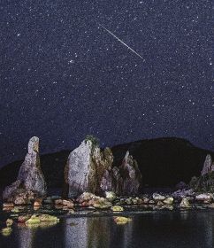 国の名勝・天然記念物「橋杭岩」の上で輝いた流れ星（１４日午後９時３３分、和歌山県串本町くじの川で）