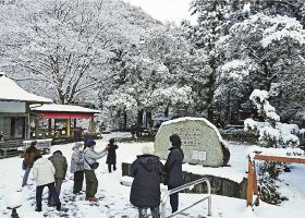 積雪した熊野古道・滝尻王子を訪れるバスツアーの観光客（２７日午前９時半ごろ、和歌山県田辺市中辺路町で）