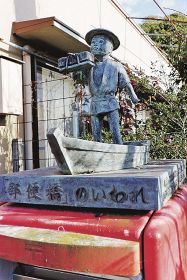 郵便橋近くのポストの上にある小舟に乗って郵便物を運ぶ少年のオブジェ（上富田町岩崎で）