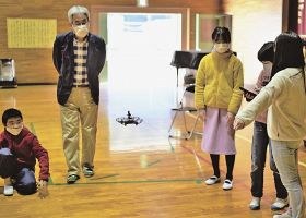 清水晴夫さん（左から２人目）に教わりながらドローンを飛ばす児童＝２２日、田辺市龍神村湯ノ又で