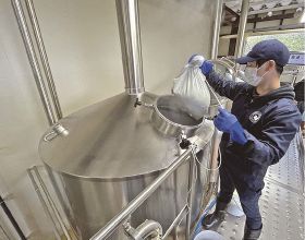 空港ビールを造るため、ホップをタンクへ入れる「ナギサビール」のスタッフ＝昨年２月、和歌山県白浜町で