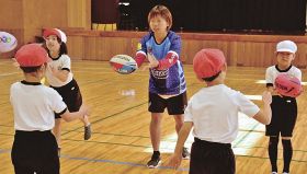 タッチラグビーを児童に教える倉石佳奈さん（１４日、白浜町の白浜第一小学校で）