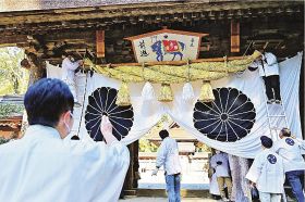 熊野本宮大社の神門に新しい大しめ縄を掲げる関係者（２４日、和歌山県田辺市本宮町で）