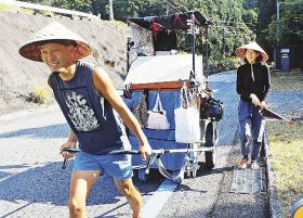 リヤカーを引き、ごみを拾いながら日本一周に挑戦している籔根頌己さんと晃子さん（７日、和歌山県白浜町椿で）