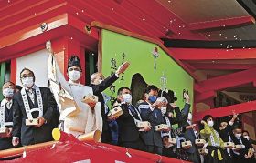 熊野那智大社の節分祭鬼追い追儺式で、マスク姿で豆をまく関係者（２日、和歌山県那智勝浦町那智山で）