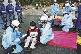 傷病者の状態を見て搬送する訓練をする消防救急隊