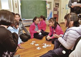 中国から訪問した児童とかるたをして交流する、安居小学校の児童ら（１７日、和歌山県白浜町安居で）