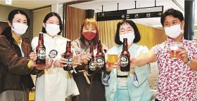 「空港ビール」を持つ岡田信一郎社長（右）ら＝２１日、和歌山県白浜町の南紀白浜空港で