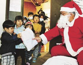 クリスマス会に参加し、サンタクロースからプレゼントをもらう子どもたち（和歌山県串本町串本で）