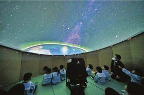エアドーム式プラネタリウムで宇宙空間を旅しているような映像を楽しむ子どもら（１４日、和歌山県那智勝浦町天満で）