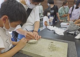 貝の化石をクリーニングする子どもたち（和歌山県串本町潮岬で）