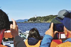 クルーズ体験で潮岬灯台を船の上から眺める参加者