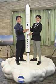 小型ロケットの模型を制作して寄贈した石田貴志さん（左）と田嶋勝正町長＝２９日、和歌山県串本町串本で