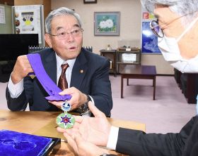真砂充敏市長（右）に名誉都民章のメダルを見せる早田卓次さん＝和歌山県田辺市役所で