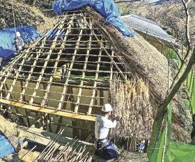 熊野古道の名所「とがの木茶屋」のかやぶき屋根をふき替える工事をする職人（和歌山県田辺市中辺路町で）
