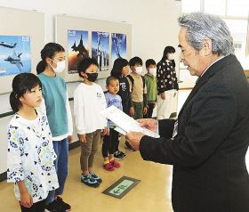 賞状を読み上げる池田三明館長（右）と表彰される児童たち＝和歌山県串本町図書館で