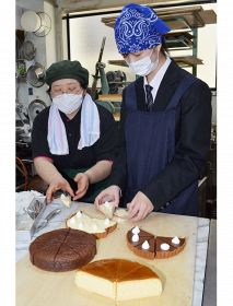 スタッフに教わりながら、ケーキをショーケースに出すための準備作業をする坂本陽菜さん（右）＝和歌山県みなべ町北道で