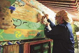 絵柄の剝がれかけた所を貼って彩色を保存する文化財修復師（和歌山県みなべ町西本庄で）