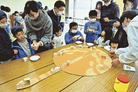 串本町から打ち上げられるロケットをモチーフにしたモニュメントを制作する子どもら（和歌山県串本町西向で）